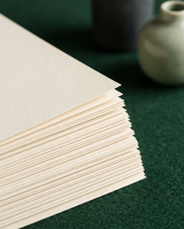 The fanned edges of a stack of cream paper